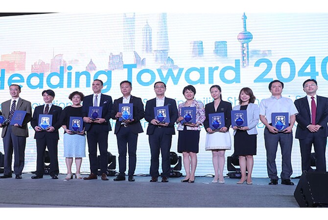 A group of people standing in line on a stage holding a plaque