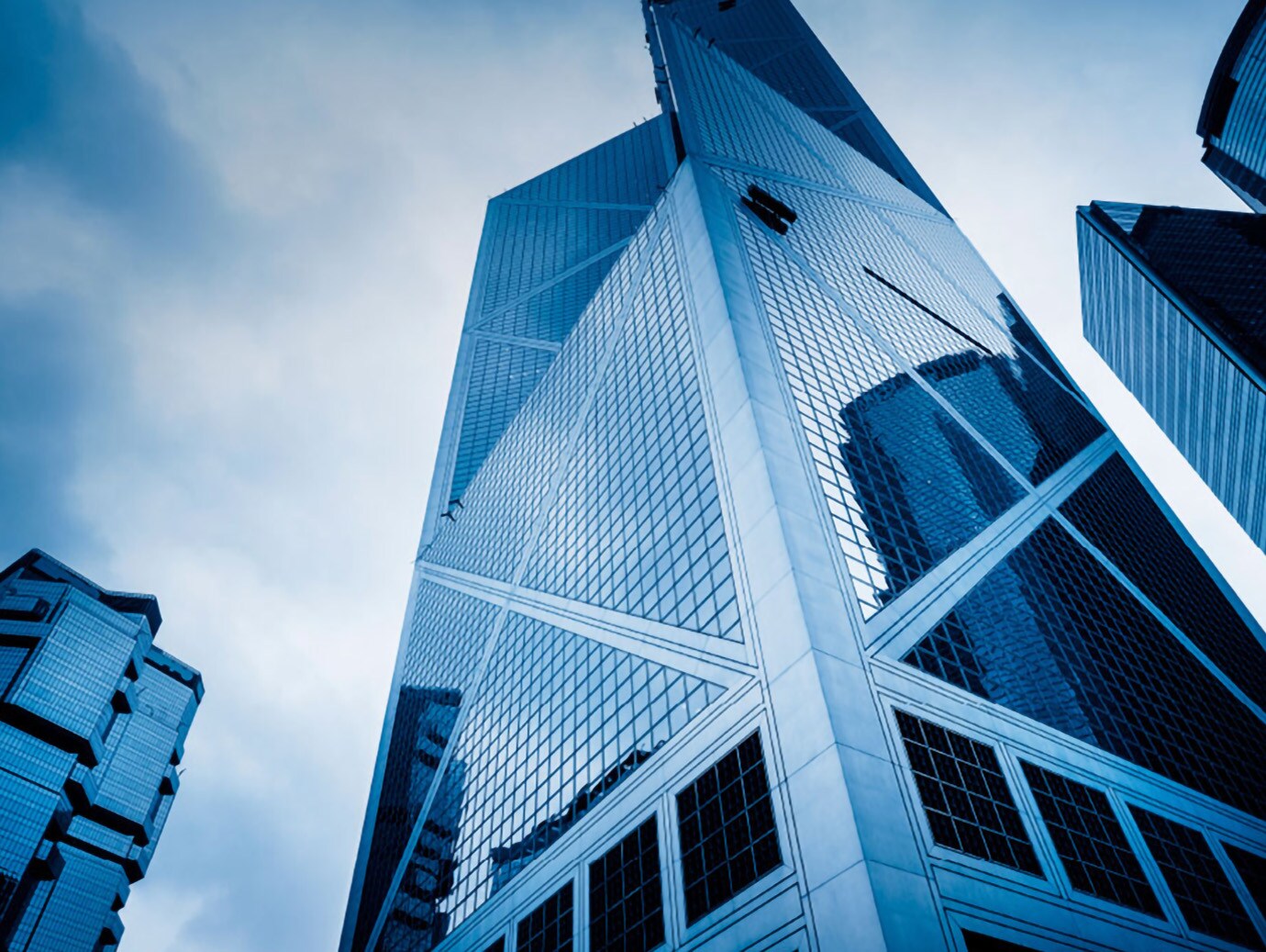 Frog's-eye view of blue skyscrapers against a daytime sky