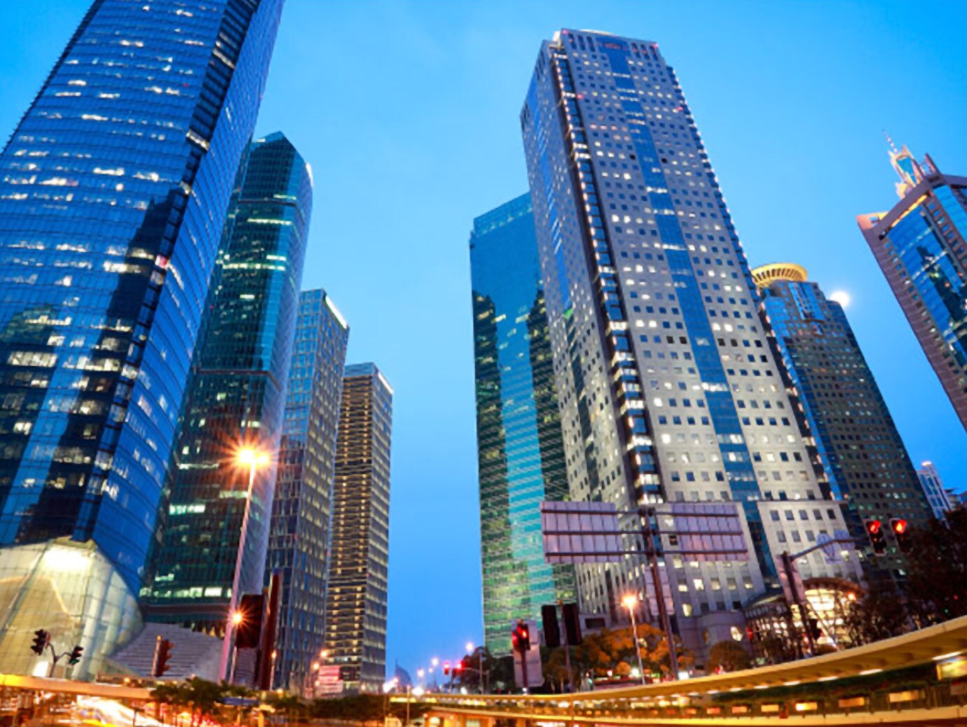 Skyscrapers along a highway lit up at twilight